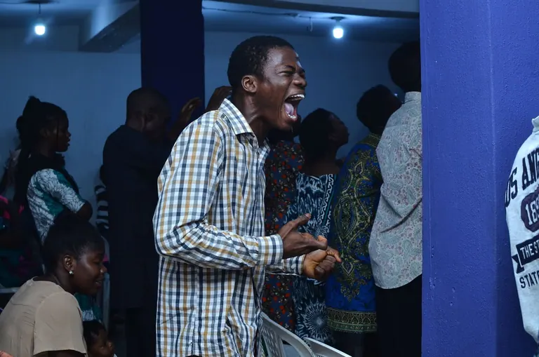 A man in a checked shirt in passionate prayer at EPAC 2024